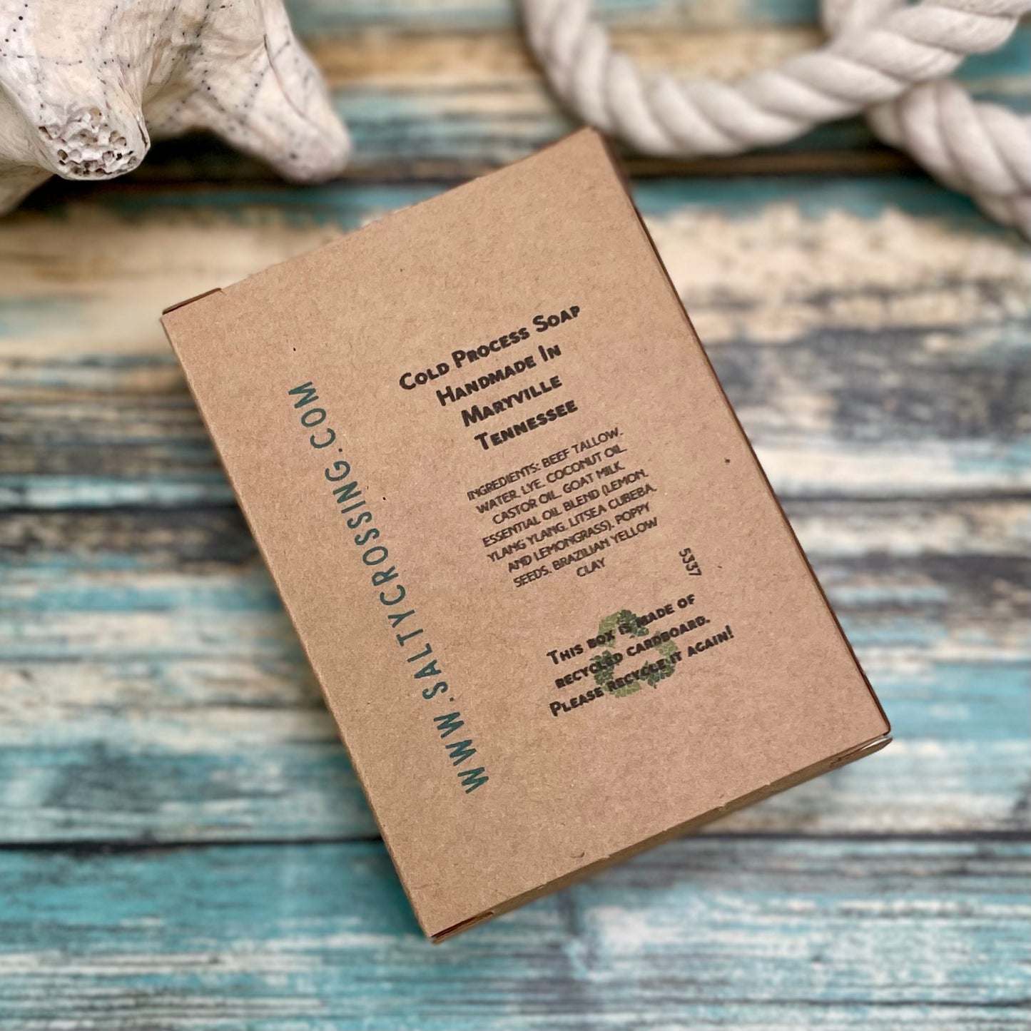 Brown soap packaging with text on a wooden surface