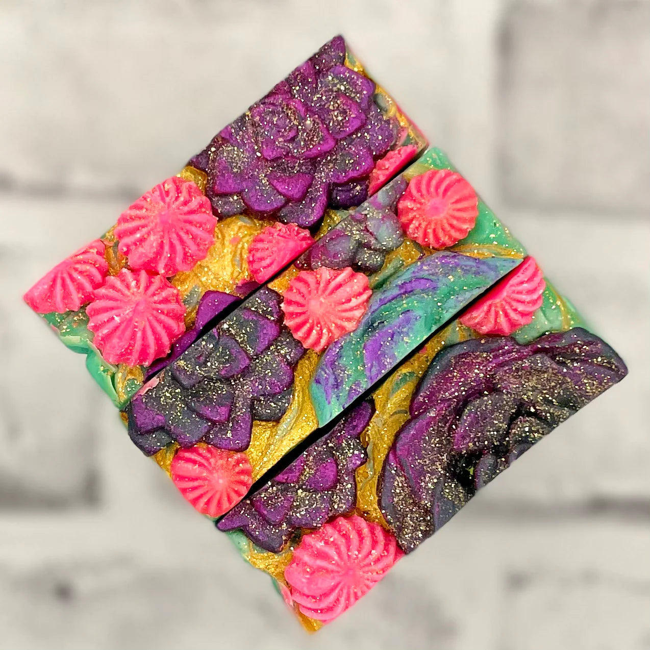 Succulent coconut milk soap closeup of hand pressed and piped plants on top