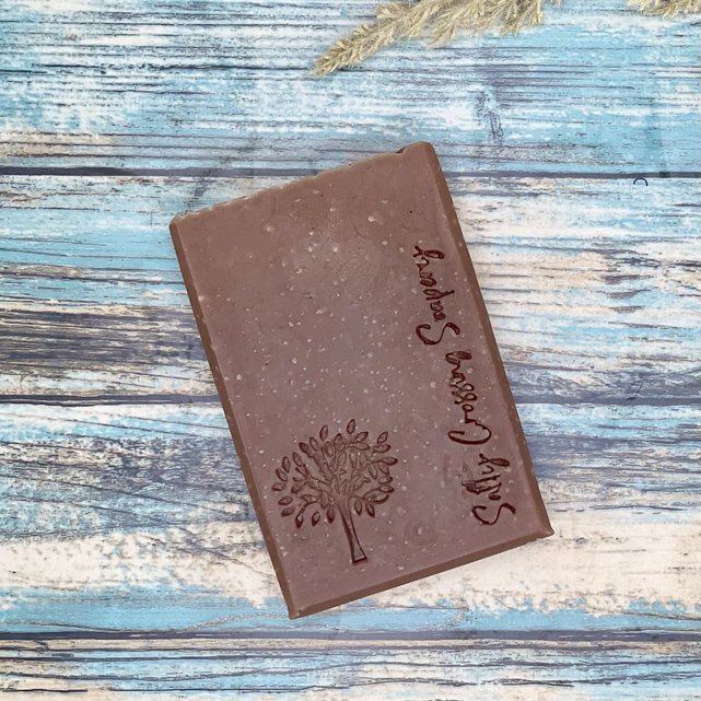 Close up of woodland walk goat milk soap bar. Brown bar with tree graphic and salty crossing Soapery text