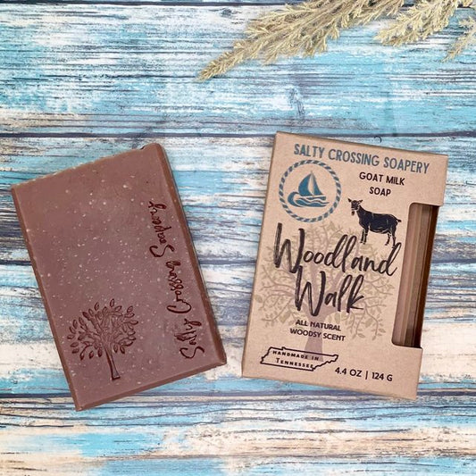 Woodland walk goat milk soap with box. Brown bar stamped with tree graphic and salty crossing Soapery text. Woodgrain texture on top
