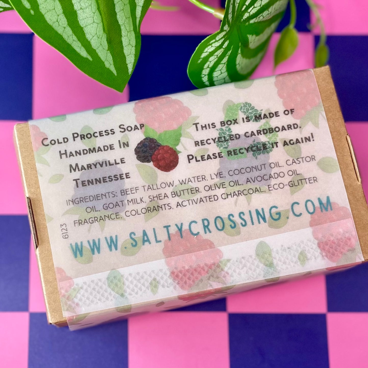Soap packaging with a berry pattern label on a pink and blue checkered background