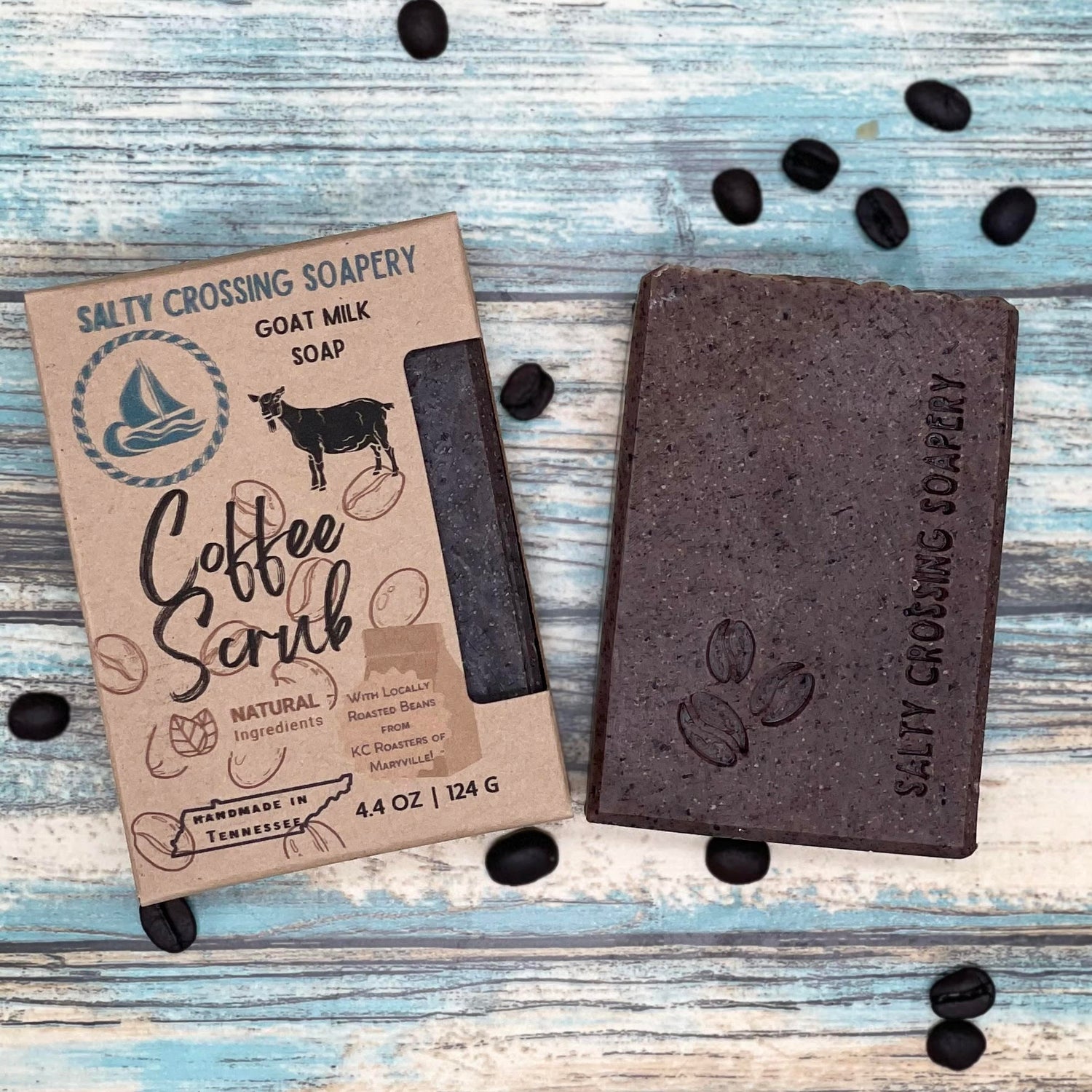 Coffee scrub goat milk soap with box. Dark brown bar stamped with coffee bean graphic and salty crossing Soapery text