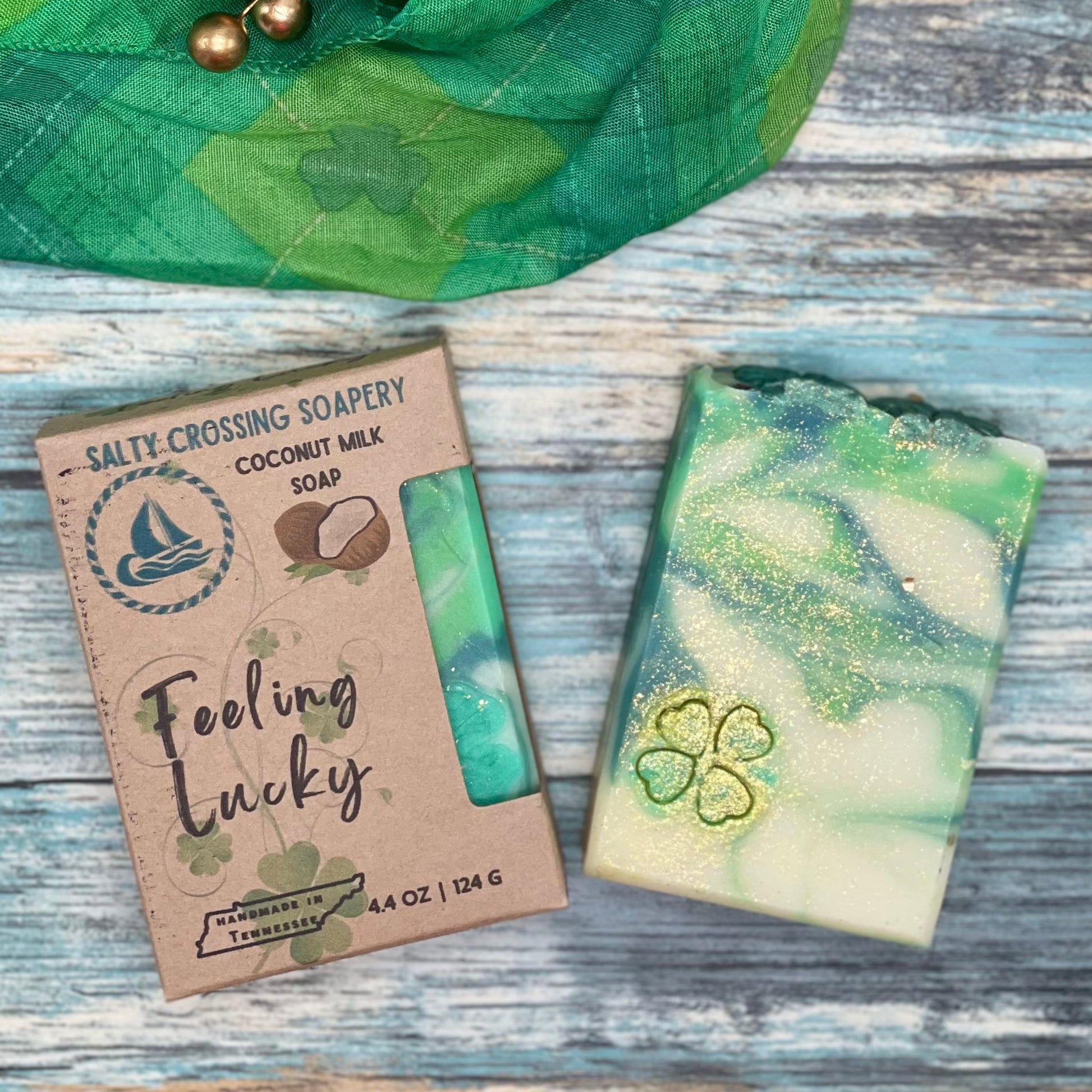 Feeling lucky soap bar and box. The bar is swirled with 2 shades of green plus white. There’s a 4 leaf clover stamp on the face, with lots of gold dust sparkles. The box is kraft paperboard with color text and graphics.