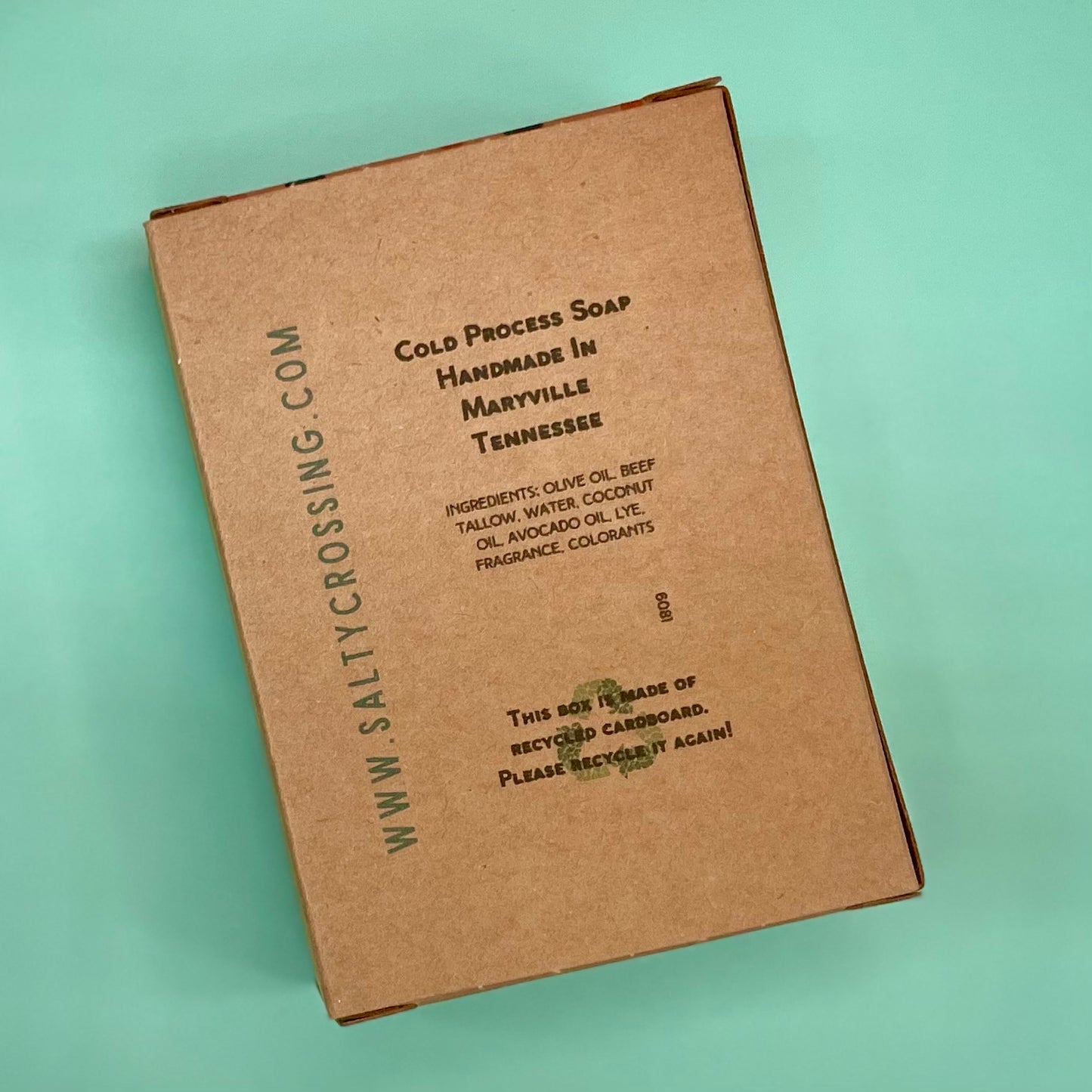 Brown cardboard soap packaging with text on a light green background
