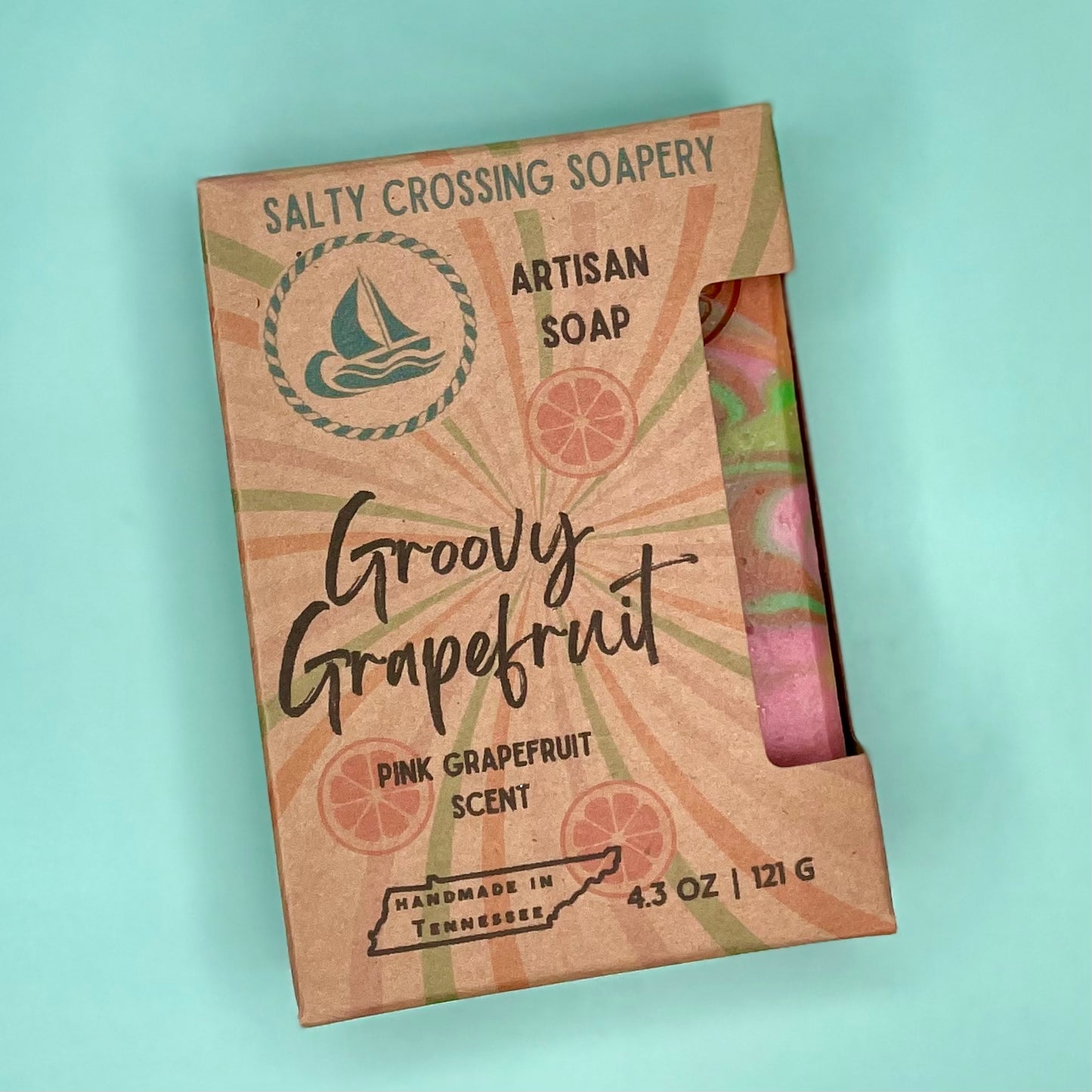 Salty Crossing Soapery artisan soap packaging with pink grapefruit scent on a light blue background
