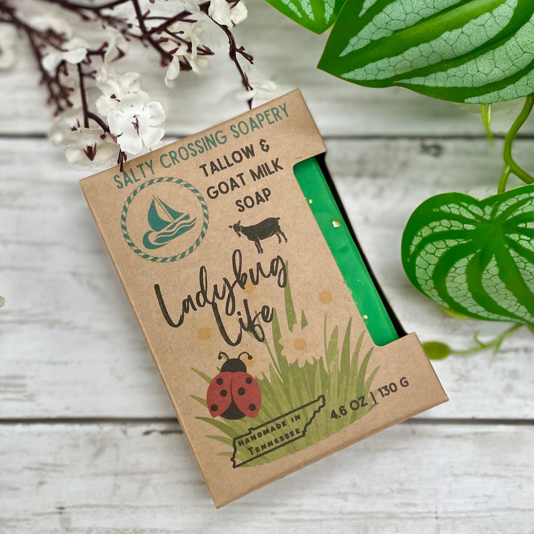 Salty Crossing Soapery soap bar in a cardboard packaging with nature-themed design on a wooden surface.