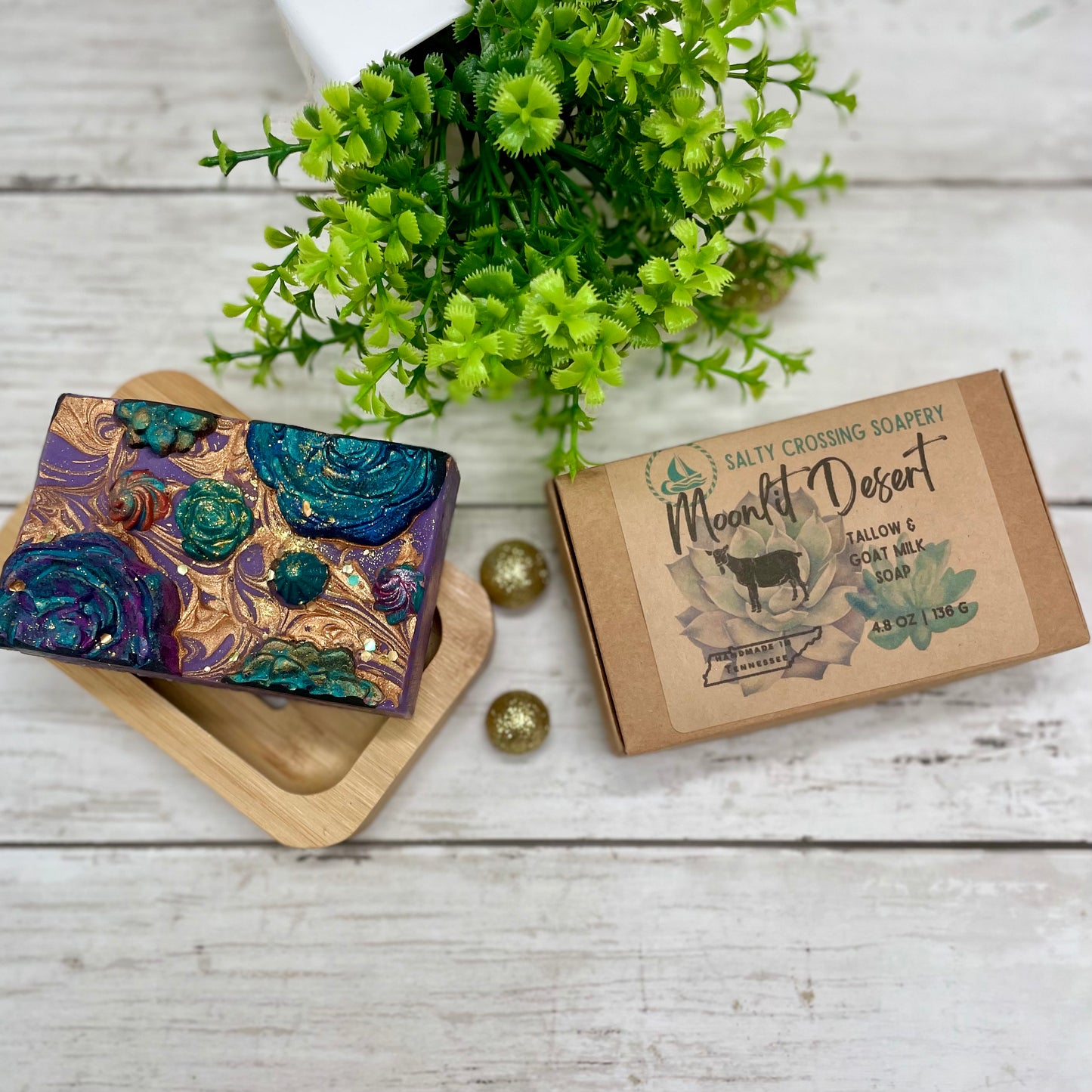 Colorful soap bar with decorative packaging on a wooden surface with greenery