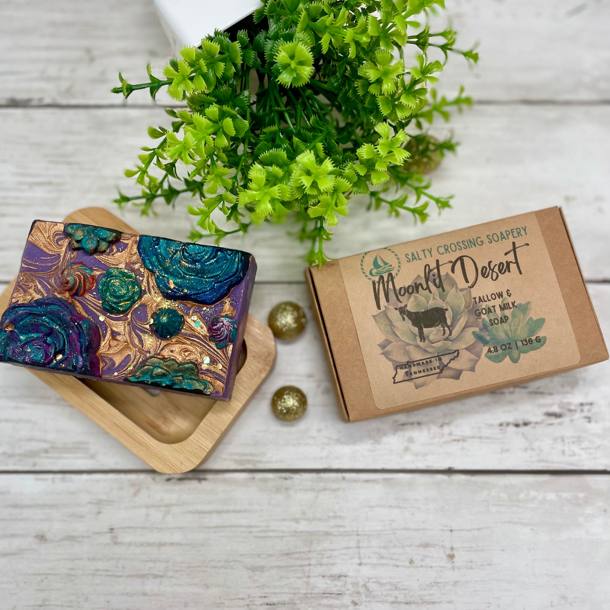 Colorful soap bar with decorative packaging on a wooden surface with greenery