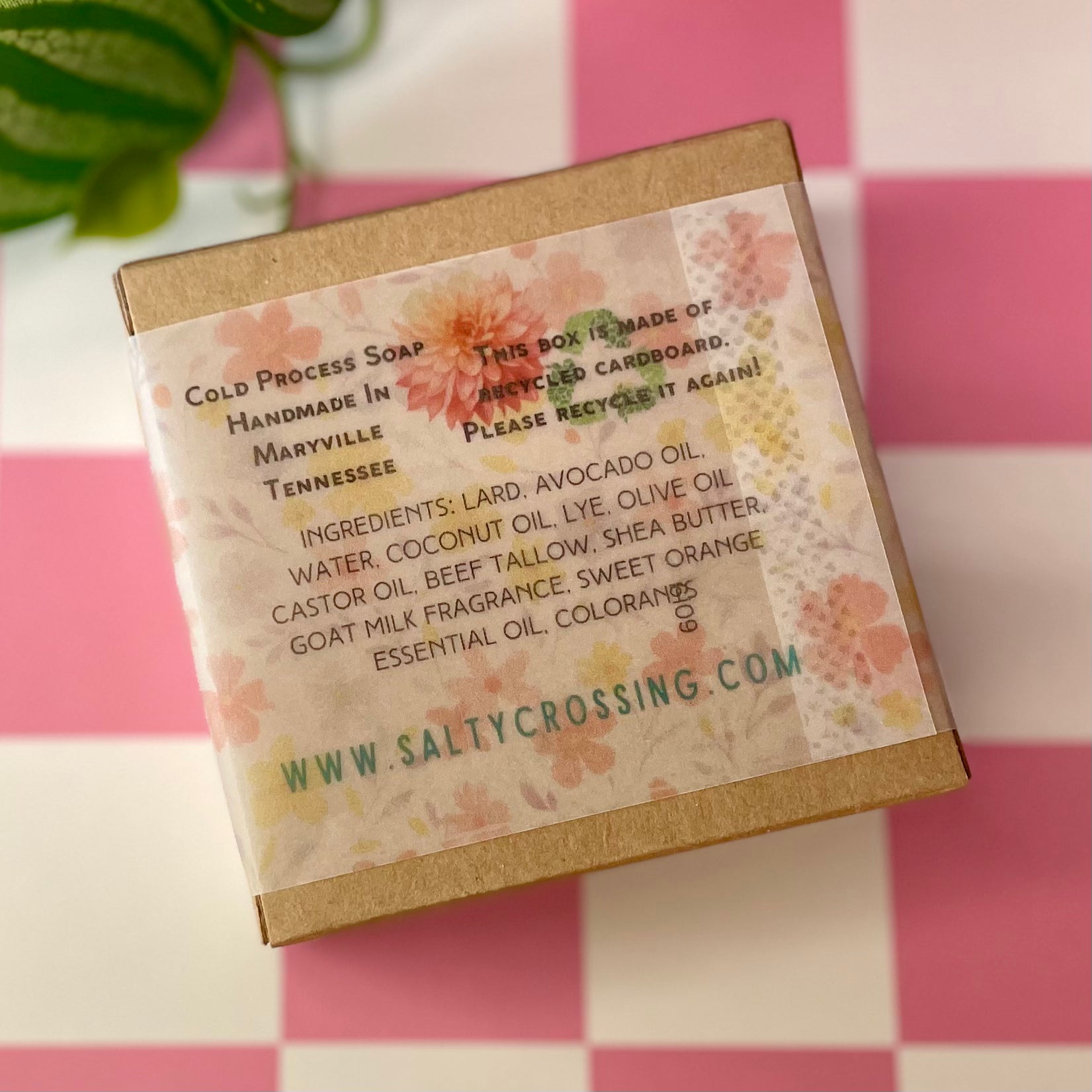 Box of handmade soap with floral design and text on a pink and white checkered background