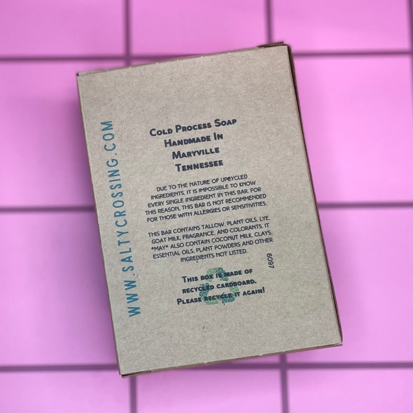 Soap packaging with text on a pink tiled background