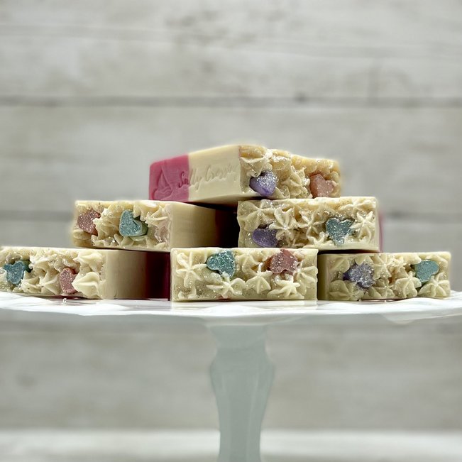 candy heart artisan soaps stacked on white cake stand.