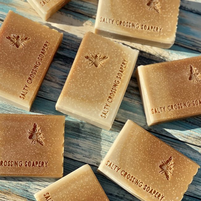 Honey and oats goat milk soap bars. Golden bars stamped with bee graphic and text salty crossing Soapery