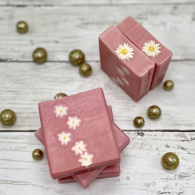 pink coconut milk bar soap with soap daisies inside and on top