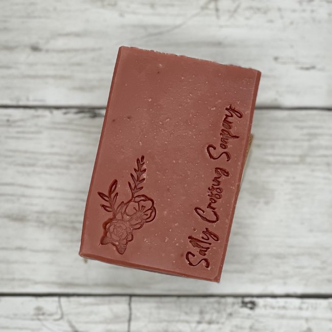 dark pink soap with rose and Salty Crossing Soapery brand stamped on the front