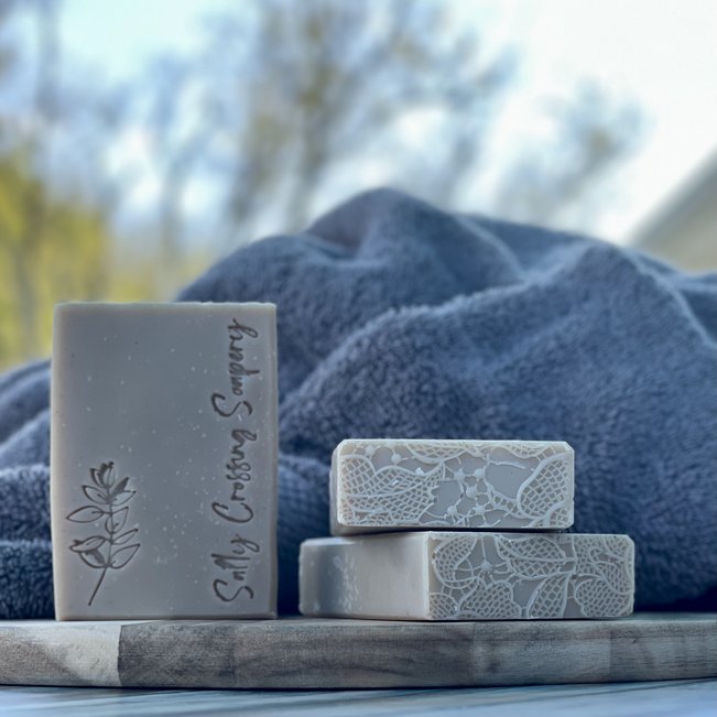 stack of rosemary mint goat milk soaps with towel