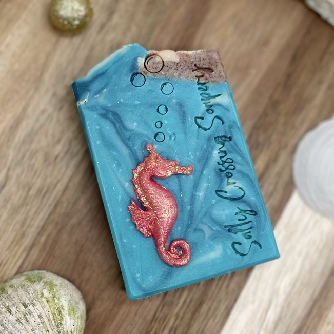 treasure coconut milk soap with fancy seahorse on front and beach with seashells on top.