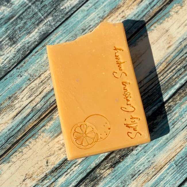 Ohhh! Orange coconut milk artisan soap. orange color with Salty Crossing Soapery and an orange stamped on the front. bio glitter sparkles on top