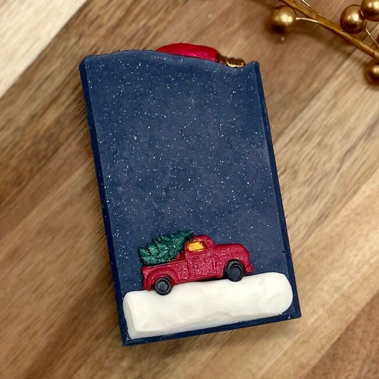 deep sparkly blue soap with snow and a red vintage truck with christmas tree