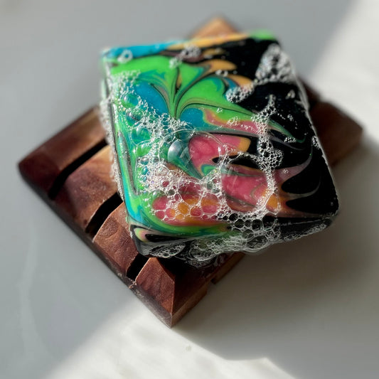 Colorful soap lathered up on wooden soap dish